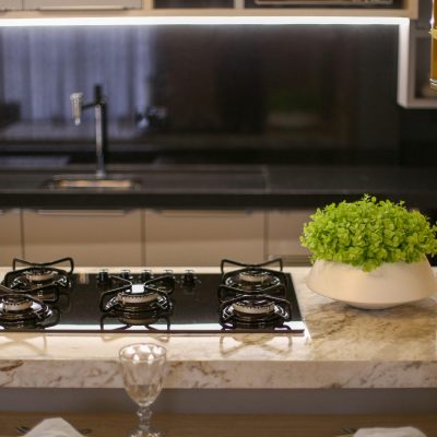A stylish kitchen featuring a gas stove, marble top, and indoor plants. Perfect for home interior inspiration.